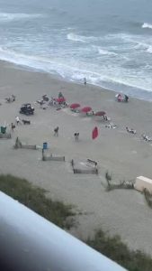 Wind Blows Umbrella Into Beachgoer