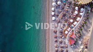 Beach umbrella and bar, turquoise sea water washing shoreline of Mediterranean coast in Albania
