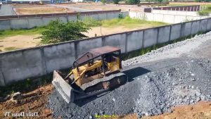 A lot of Dump Truck 25 Ton Unloading Stone and Huge Dozer Komatsu Pushing Stone Fill the land